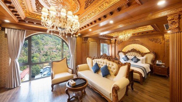 A luxurious room with a large bed, a sofa, and a chandelier. - Glenda Tower Moc Chau Hotel (Moc Chau)