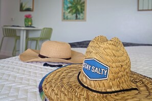 A bed with a woven hat and a blanket.