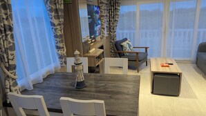 A modern living room with a wooden coffee table, a sofa, and a TV mounted on the wall. - Lighthouse Lodge Dog Friendly Nr Sutton on Sea (Sutton on sea)