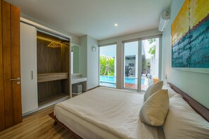Un dormitorio con una cama grande, vestidor y vistas a una piscina.