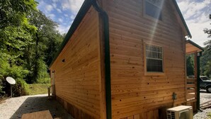 A wooden cabin with a sloped roof, a window, and a small porch area. - Peaceful cabin in the center of riding country!  (Duff)