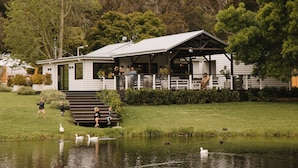 A lakeside lodge with a covered patio and a pond with ducks. - Ampersand Estates (Peerabeelup)