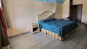 Un dormitorio con cama, mesita de noche y techo decorado con un diseño de nubes.