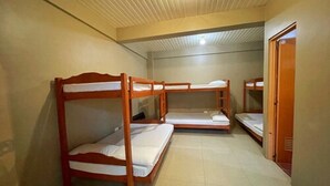 A room with three wooden bunk beds, a tiled floor, and a door on the right. - Weekdays Hot Spring Resort by Cocotel (Calamba)