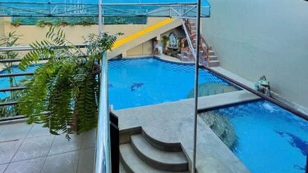 A swimming pool with a view of a blue sky and a distant landscape. - Weekdays Hot Spring Resort by Cocotel (Calamba)
