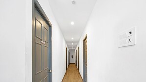 A corridor with doors labeled "PRIVATE" and a wall-mounted electrical outlet. - UPAR Hotels Uthandi ECR (Chennai)