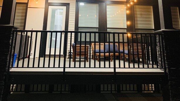 A covered porch with string lights, a railing, and a bench. - Stylish, clean&cozy new 2 bedroom guest suite (Abbotsford)