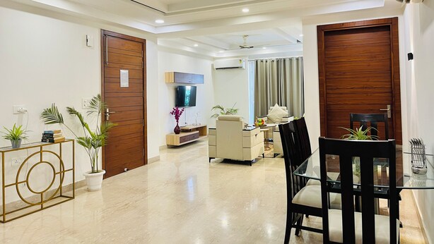 Uma sala de estar moderna com televisão, área de estar e mesa de jantar.