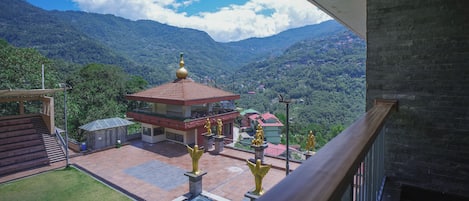 A view of a building with a red roof and a golden statue in front.