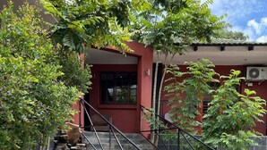 A staircase leading to a building entrance, surrounded by greenery and a small water feature. - Novel Enterprises Bed and Breakfast (Rustenburg)