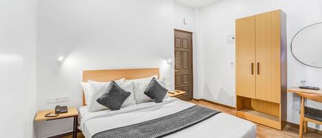 Un dormitorio ordenado con cama, mesita de noche, armario y ventilador de techo.