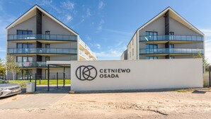 A modern apartment building with a sign reading "CETNIEWO OSADA".