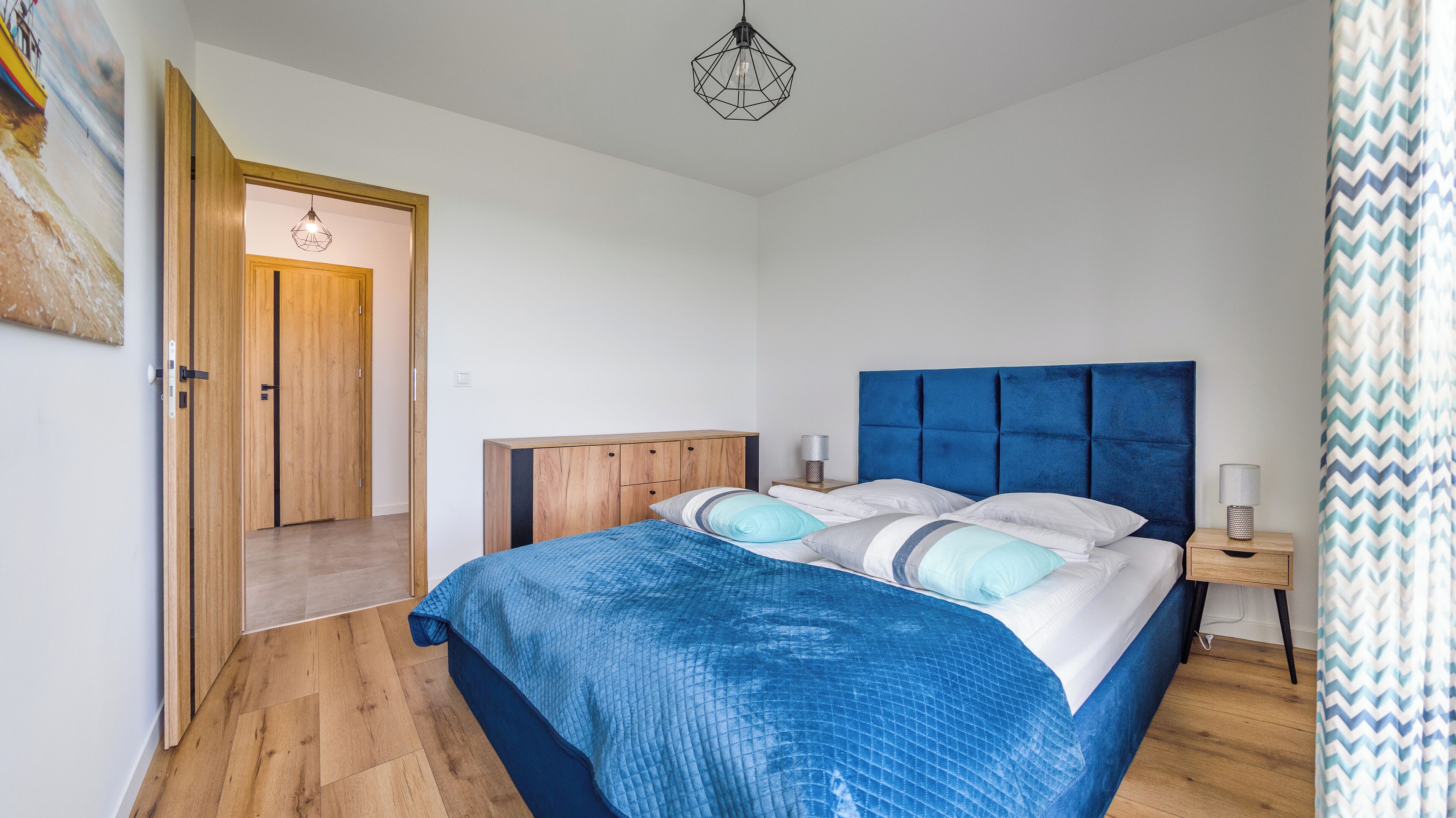 Une chambre à coucher avec un lit, une armoire en bois et une porte donnant sur une autre pièce.