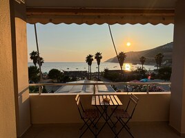 Un balcón con vista al mar y al atardecer.