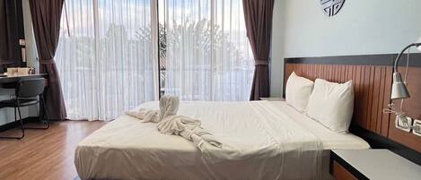 A modern hotel room with a large bed, a desk, and a chair.
