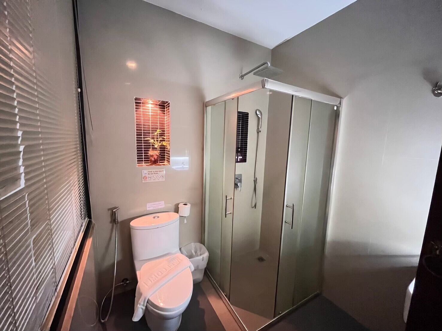 Une salle de bain comprenant des toilettes, un bidet et une cabine de douche en verre.