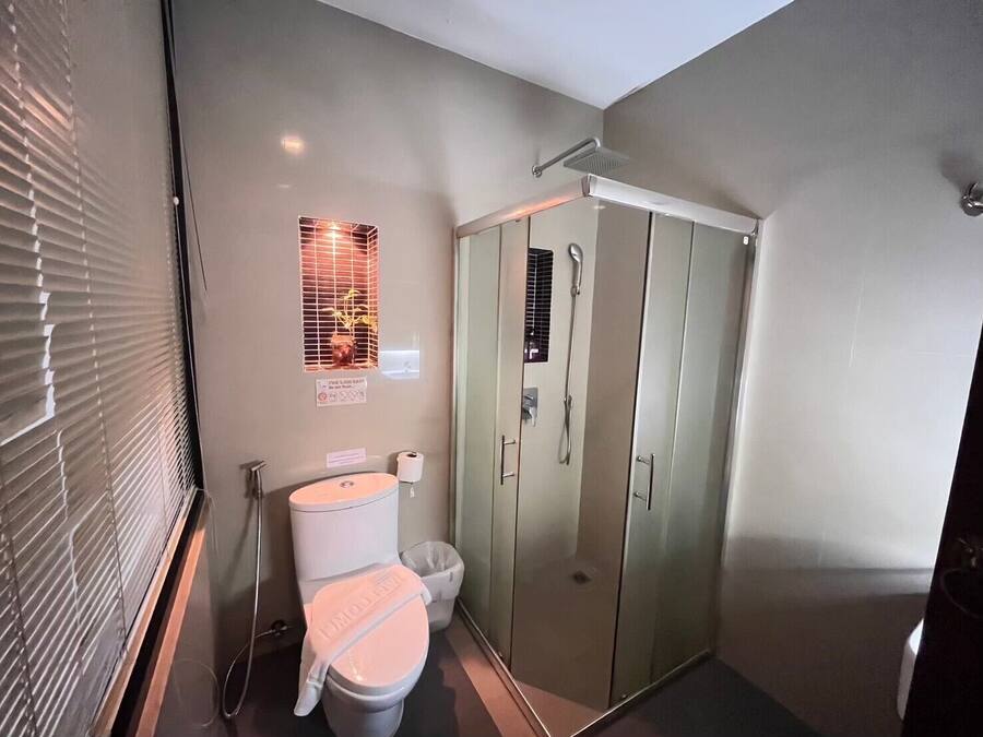Une salle de bain comprenant des toilettes, un bidet et une cabine de douche en verre.