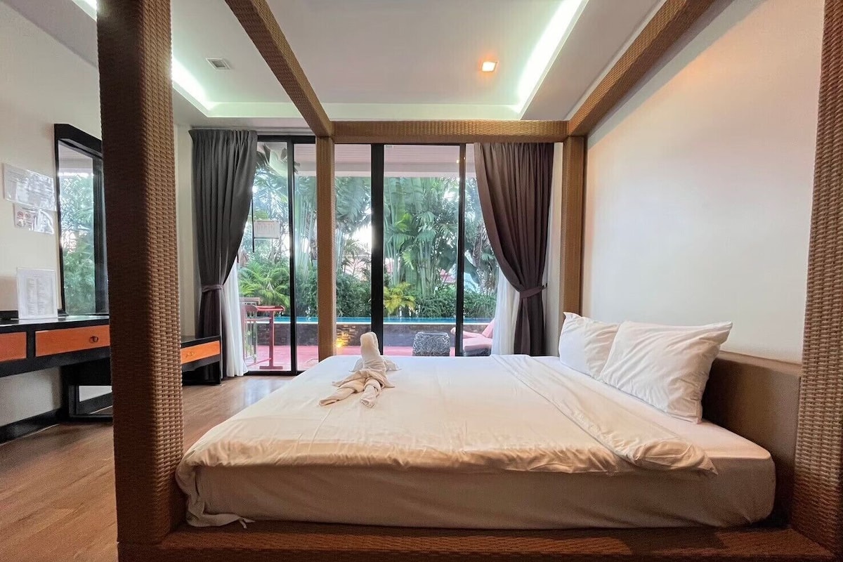 A hotel room with a large bed, a desk, and a view of the outdoors.