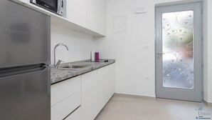 Una cocina moderna con un refrigerador de acero inoxidable, un microondas y una encimera de granito.