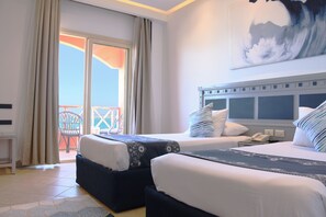 Une chambre d’hôtel avec deux lits, un balcon donnant sur un beau paysage et un tableau accroché au mur.