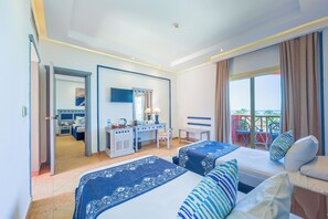 Une chambre d’hôtel avec deux lits, un bureau, une chaise, une télévision et un balcon équipé de chaises.