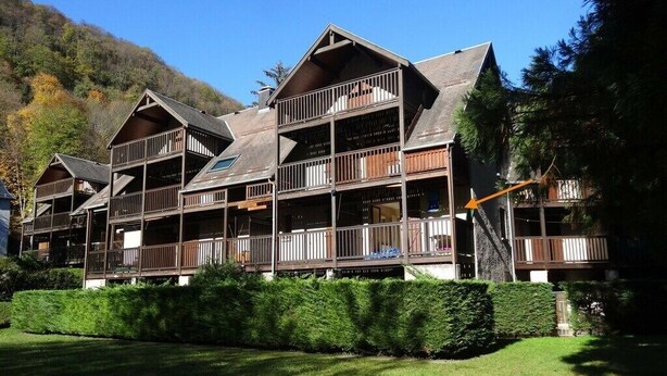 A multi-story lodge with balconies and a well-maintained lawn.