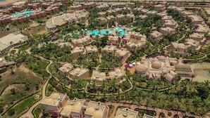 An aerial view of a resort with multiple buildings, palm trees, and a central swimming pool. - TH Blue Lagoon Marsa Alam (Marsa Alam)