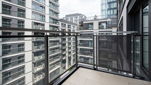 Un immeuble d’appartements moderne doté de nombreux balcons, de grandes fenêtres et offrant une vue sur d’autres immeubles.