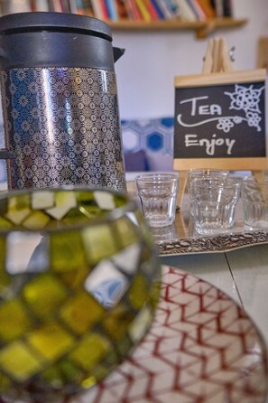 A coffee setup with a patterned thermos, a glass pitcher, and a sign that says "Tea Enjoy". - My Way Kite & Surf House (Ilhavo)