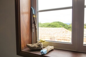 A window sill with two pieces of driftwood and a blue and yellow object. - My Way Kite & Surf House (Ilhavo)