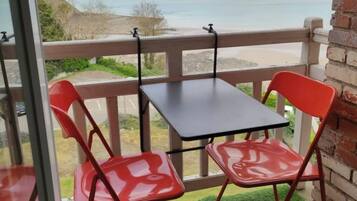 Enjoy the breathtaking ocean views from this balcony, featuring a comfortable seating area with two chairs and a table.