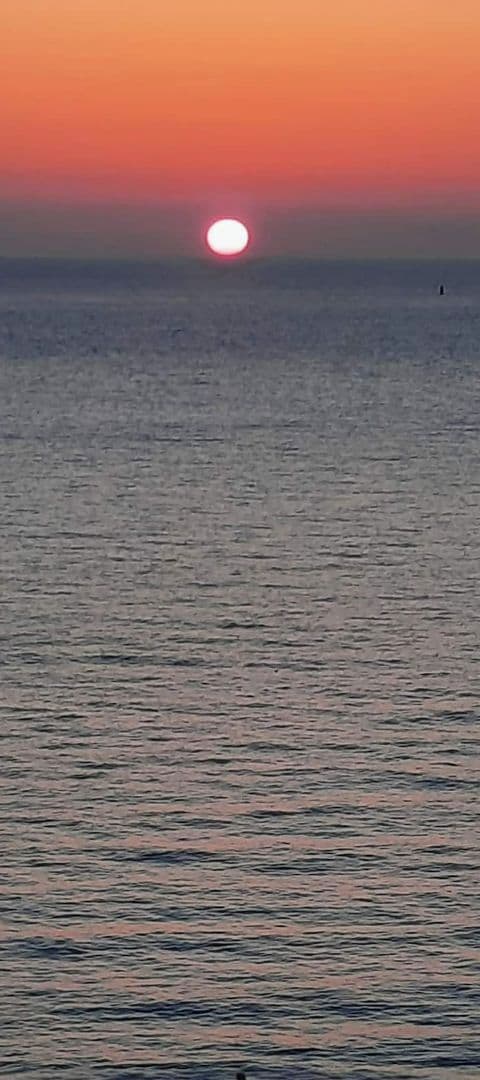 Un coucher de soleil sur une mer calme.