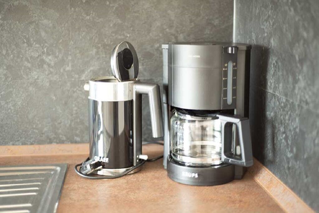 Eine Kaffeemaschine und ein Kaffeekännchen auf einer Arbeitsplatte.