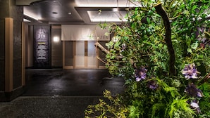 L’entrée d’un hôtel au design moderne, avec un comptoir d’accueil et une enseigne indiquant « HÔTEL ZEN ».