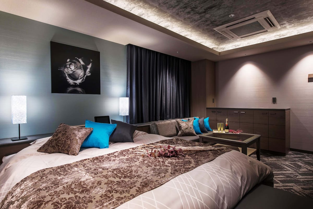 Een moderne hotelkamer met een groot bed, een bureau en een minibar.