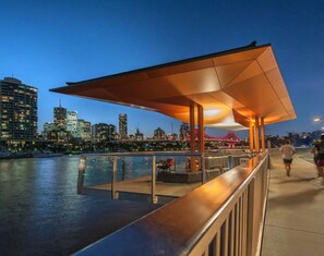 Stroll along the waterfront promenade, surrounded by a city skyline and a body of water.