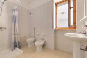 A bathroom with a shower, two toilets, a bidet, and a sink. - 2244 Residence Anna - Appartamento Sarago (Taviano)
