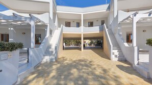 A modern building with a central courtyard, multiple balconies, and a staircase leading to the upper floors. - 2244 Residence Anna - Appartamento Sarago (Taviano)