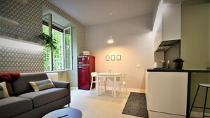 A compact living space with a sofa, dining table, and kitchenette. - SIMONA's apartment in Rome a stone's throw from St. Peter's (ROMA)