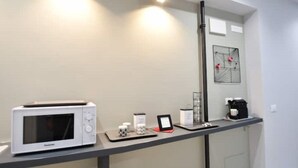 A kitchen with a microwave, coffee maker, and a small table with a picture frame and candles. - SIMONA's apartment in Rome a stone's throw from St. Peter's (ROMA)