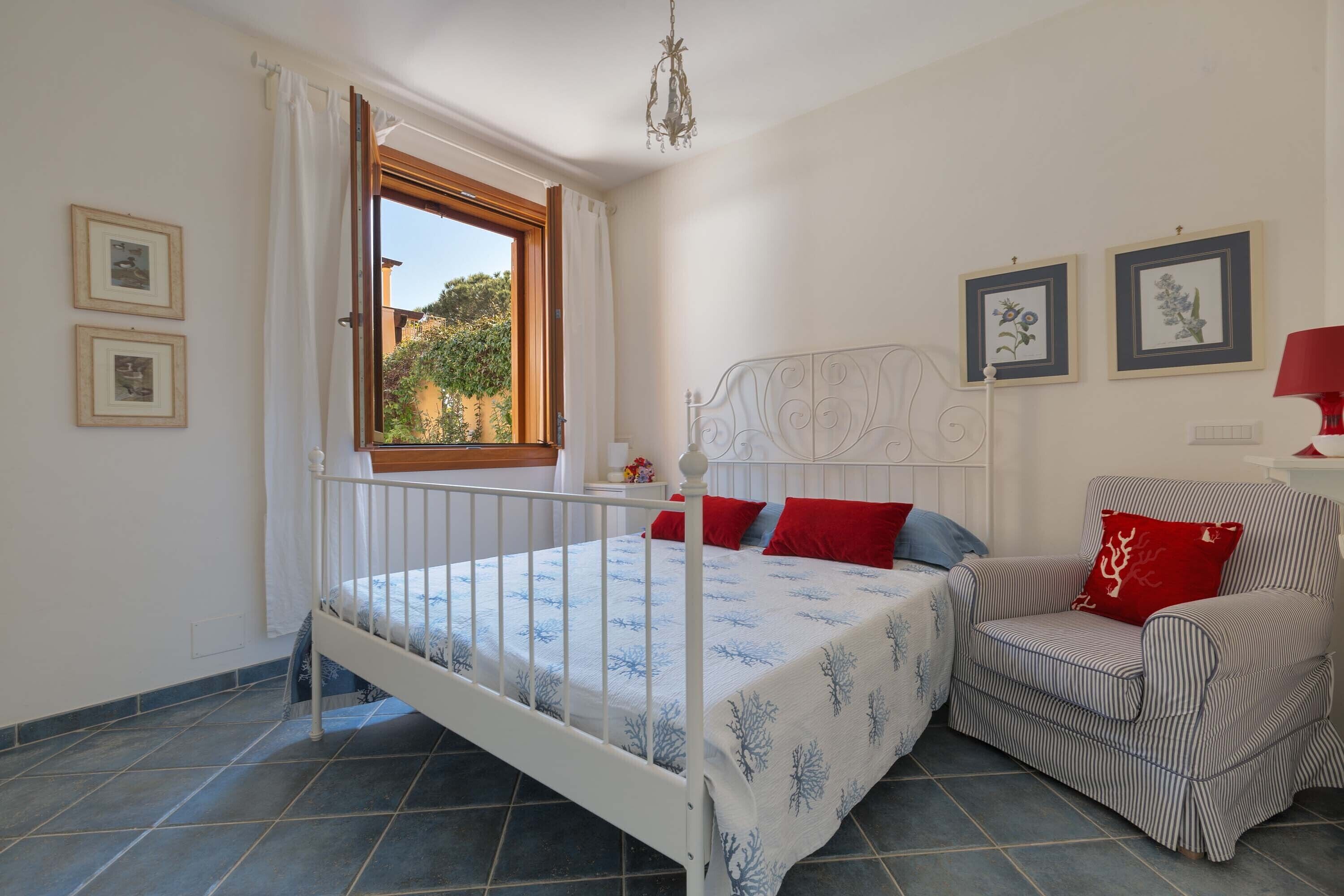 Ein Schlafzimmer mit einem Bett, einem Sessel und einem Fenster.