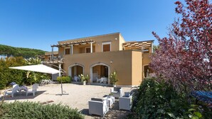Ein modernes Gebäude mit einer Terrasse, Sitzmöglichkeiten im Freien und einer Pergola.