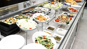 A buffet with various food options including salads, vegetables, and fruits. - Golden Tulip Hotel Alexandre (El Khroub)
