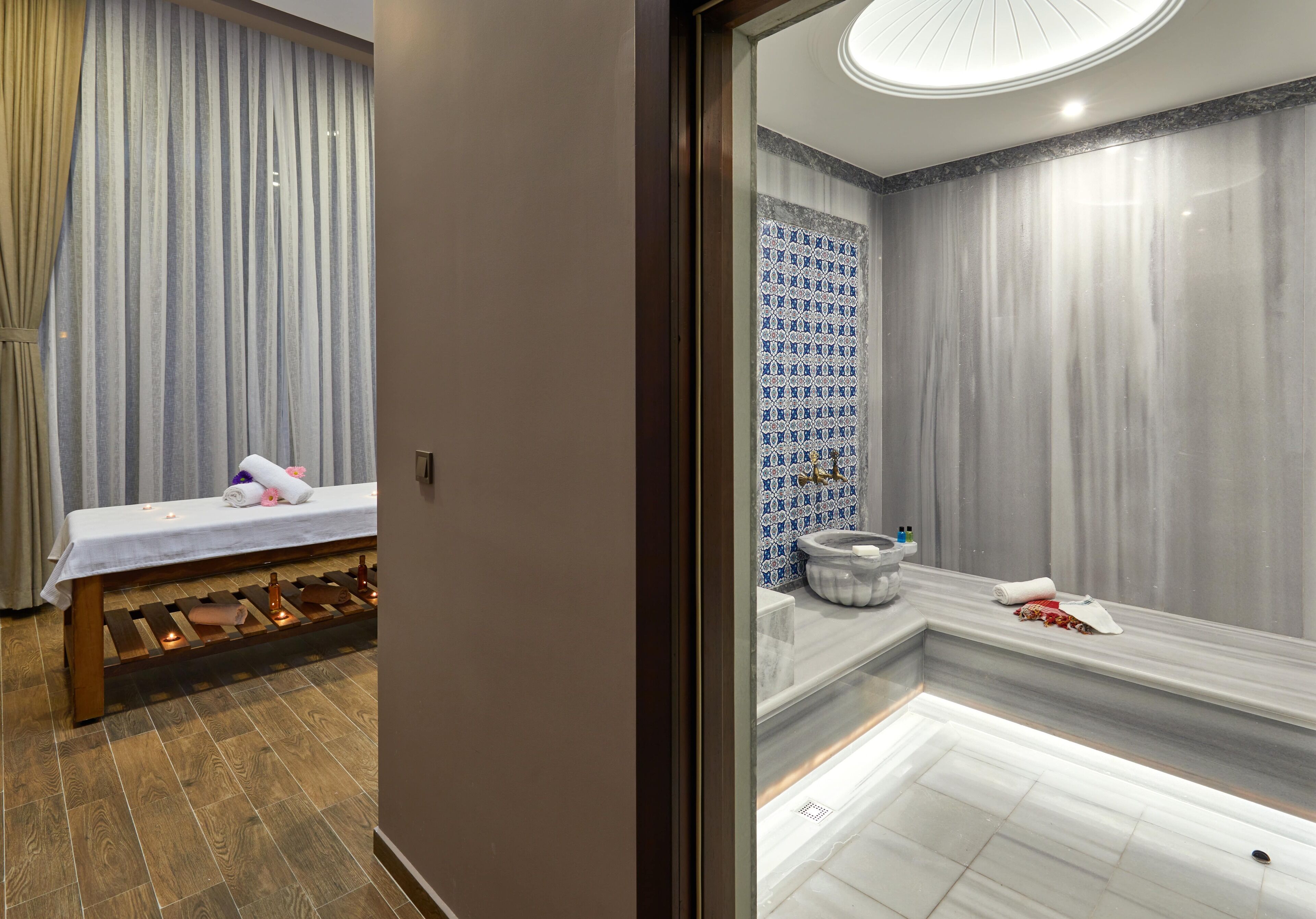 A modern bathroom with a bench, a bathtub, and a shower area.