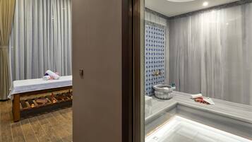 A modern bathroom with a bench, a bathtub, and a shower area.