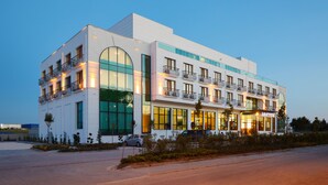 Ein modernes Hotel mit heller Fassade, großen Fenstern und Balkonen.