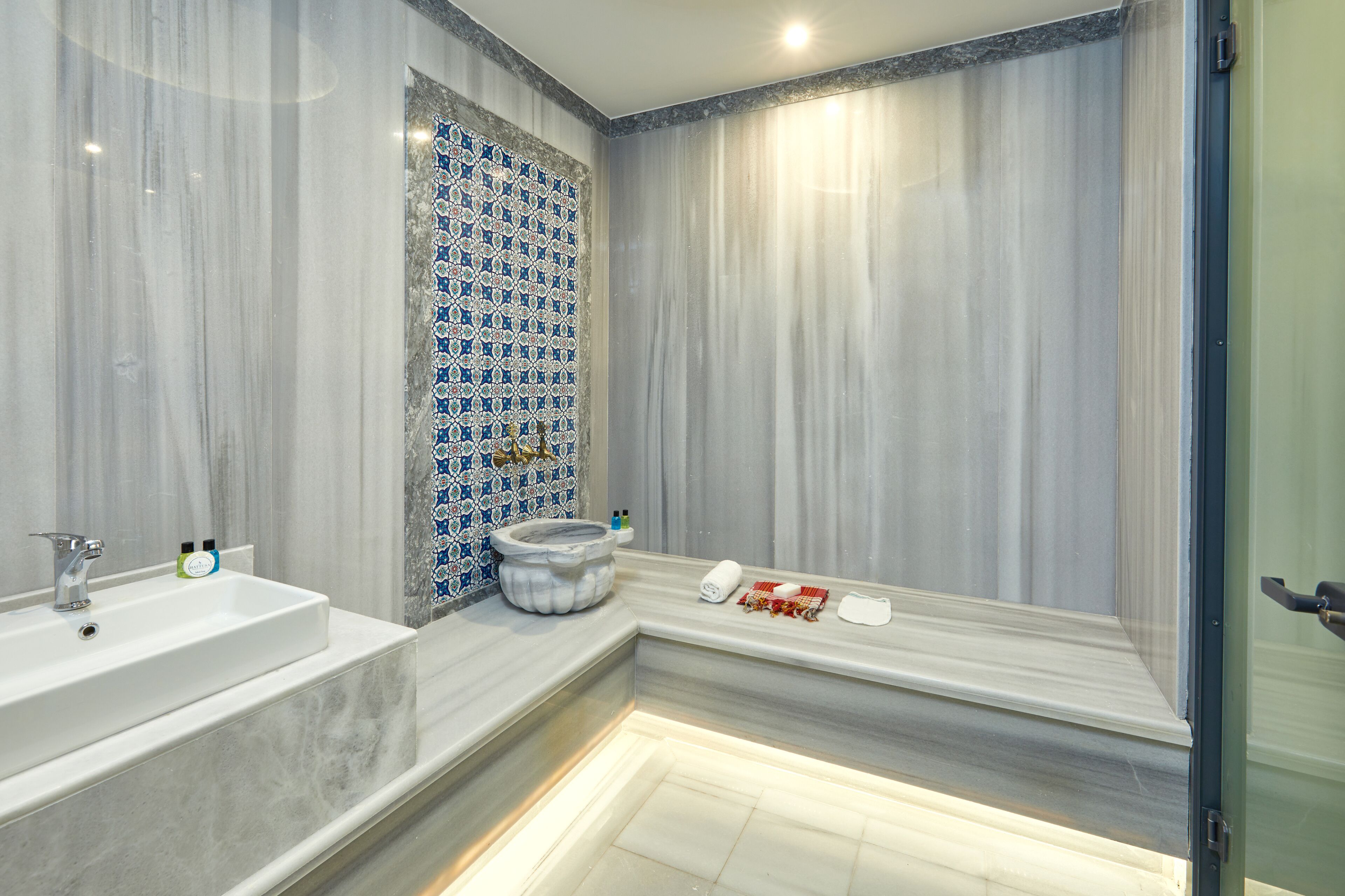A modern bathroom with a marble sink, a bathtub, and a shower area.