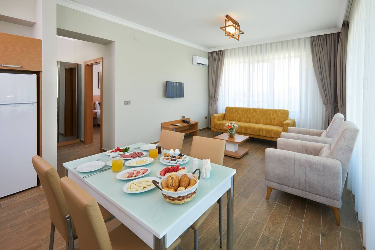 Une chambre d’hôtel moderne dotée d’un coin repas, d’un canapé et d’une télévision.