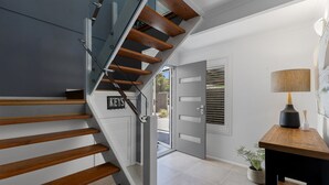 A modern staircase with wooden steps and glass railings leading to a door labeled "KEYS".