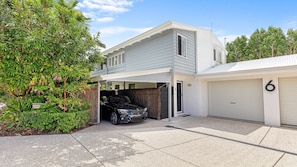 A two-story house with a garage, a driveway, and a well-maintained garden.